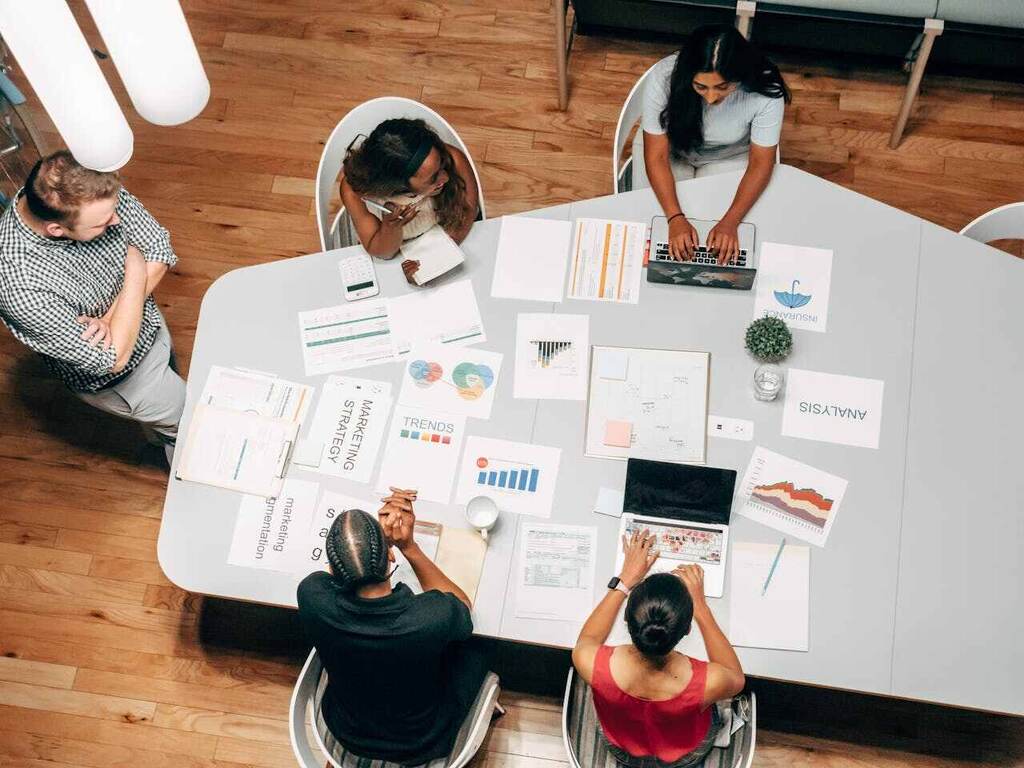 mesa com funcionários reunidos, representando a comunicação omnichannel